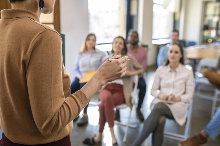 Woman Lecturer Giving a Presentation to Businesspeople