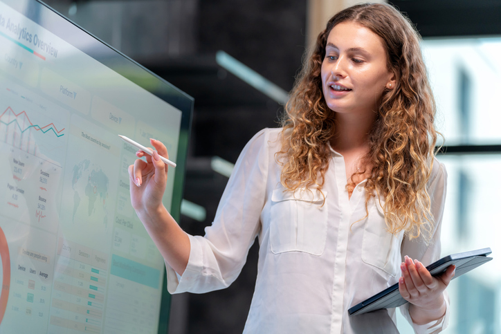 Efficient presentation of the work drives the business to grow steadily. Businesswoman sale manager present the data analysis information to management team in the meeting room and point to the important information.