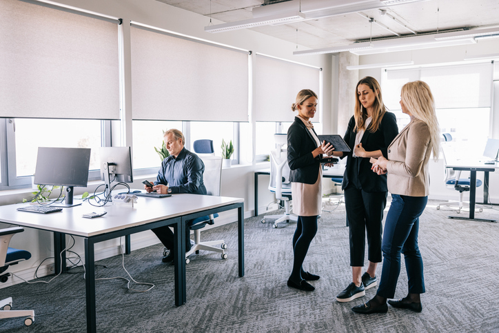 Efficiency at its best! These financial colleagues gather for a quick huddle, discussing crucial matters while on the move, exemplifying their commitment to maximizing every moment.